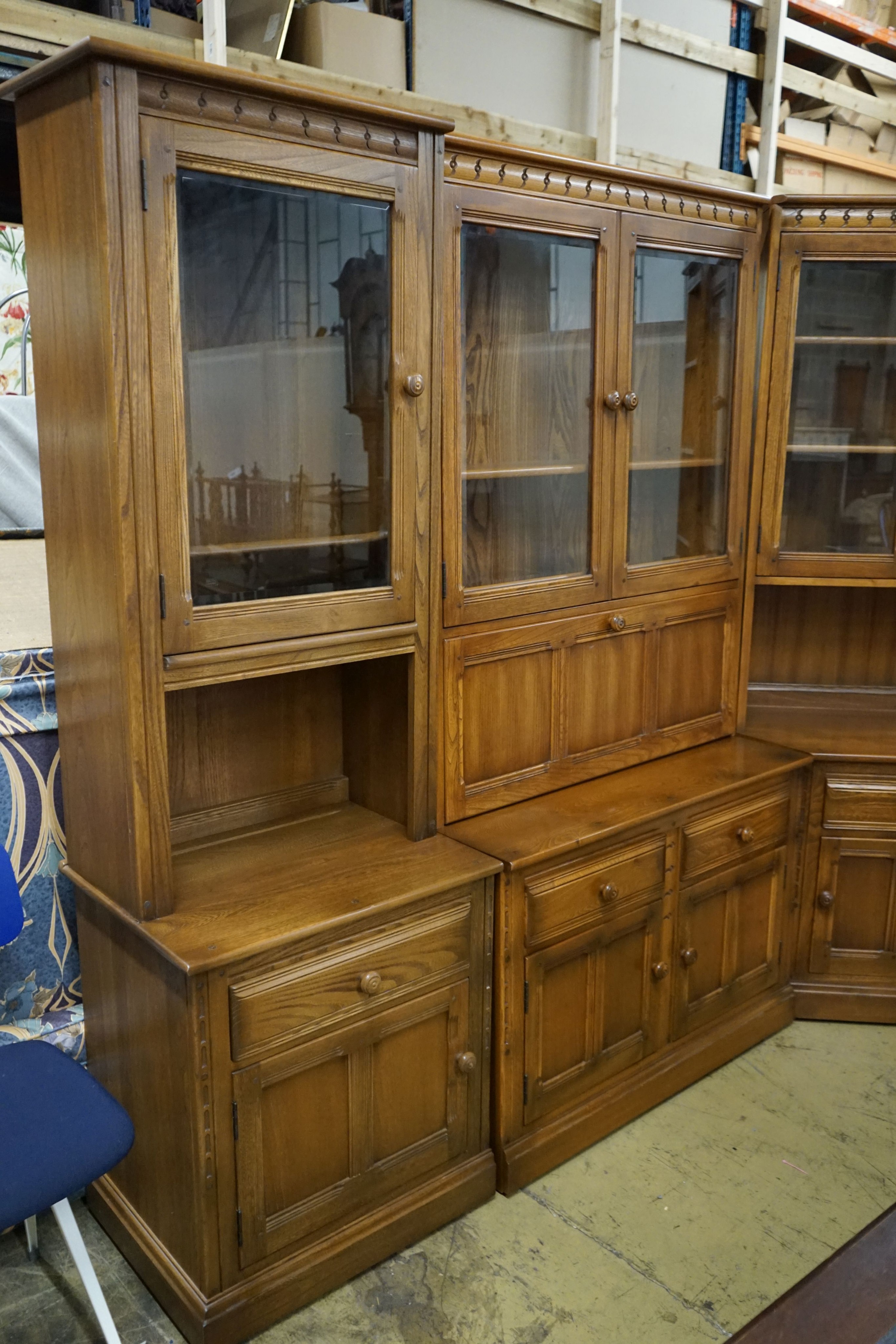 An Ercol elm four section modular wall unit, width 244cm, depth 49cm, height 197cm